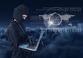 Hacker using a laptop in front of cloudy background Royalty Free Stock Photo