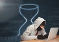 Hacker using a laptop in front of digital background with an hourglass