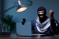 The hacker wearing balaclava mask hacking computer Royalty Free Stock Photo