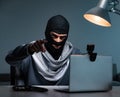 Hacker wearing balaclava mask hacking computer