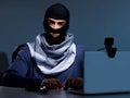 Hacker wearing balaclava mask hacking computer Royalty Free Stock Photo