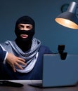 Hacker wearing balaclava mask hacking computer