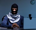 Hacker wearing balaclava mask hacking computer