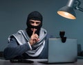 Hacker wearing balaclava mask hacking computer