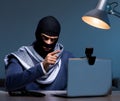 Hacker wearing balaclava mask hacking computer Royalty Free Stock Photo