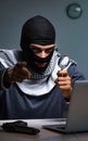 Hacker wearing balaclava mask hacking computer Royalty Free Stock Photo