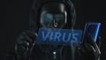 Hacker wearing black mask pulls VIRUS tab from a smartphone. Hacking concept
