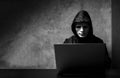 Hacker wearing a white mask in front of his computer. hacker hacks network Royalty Free Stock Photo