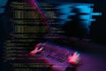 Hacker working with computer in dark room with digital interface around. Image with glitch effect. Royalty Free Stock Photo