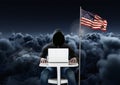 Hacker working on laptop close to the american flag with cloudy background