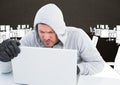 Hacker working on laptop in front of office drawing background