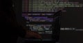 Hacker writing code cracking computer. Programming code in the background. Hacker attack, cybercrime, virus software Royalty Free Stock Photo