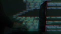 Hacker writing code cracking computer. Programming code in the background. Hacker attack, cybercrime, virus software