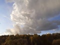 Landscape with cloud, yellow autumn forest, illuminated by the evening sun.