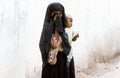 Arabic unknown mother carries her baby in a wraparound garment