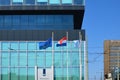 Hague, Netherlands - May 2, 2022: European Union and Netherlands flags fluttering near modern building in city Royalty Free Stock Photo