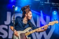 Sexy young guitarist with braids performing on stage Royalty Free Stock Photo