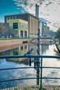 The Hague, The Netherlands - November 8, 2020: Focus on bird. A seagull on a metal fence, in the background water and factory Royalty Free Stock Photo