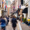 Dutch flags in busy historic street in city