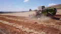 Haifa, Israel - 02 July, 2020: Wheat harvest. Drone shot flying over modern combine harvester collects ripe wheat.