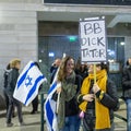 Woman holds placard: BB dicktator.