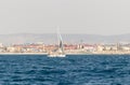 A private yacht sails in the waters of the Haifa Bay, against the background of Haifa port, in the Mediterranean Sea, near the Royalty Free Stock Photo