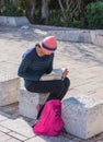 Young girl sitting outdoors and reading a book in Haifa, Israel