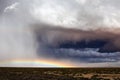 A hailbow stretches beneath dramatic storm clouds.