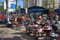 Many motorbikes in the parking lot near the fish market