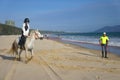 Riders riding on a horse on the beach close to the sea Royalty Free Stock Photo