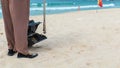 Hainan Island, Sanya, China - May 16, 2019: A cleaning lady picks up trash on Hainan Beach with special handy forceps Royalty Free Stock Photo