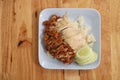 Hainanese chicken rice with Roasted Chicken on wooden table.Hainanese chicken rice is a dish of poached chicken and seasoned rice Royalty Free Stock Photo