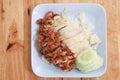 Hainanese chicken rice with Roasted Chicken on wooden table.Hainanese chicken rice is a dish of poached chicken and seasoned rice Royalty Free Stock Photo