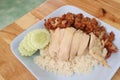 Hainanese chicken rice with Roasted Chicken on wooden table.Hainanese chicken rice is a dish of poached chicken and seasoned rice Royalty Free Stock Photo