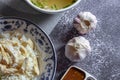 Hainanese chicken rice served in a Chinese style dish with soy sauce and broth on a gray table