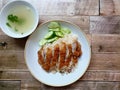 Hainanese chicken rice with sliced fried chicken, cucumber, and chicken soup