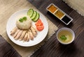 Hainanese chicken rice with soup and three sauces on dark wood table texture close up Royalty Free Stock Photo