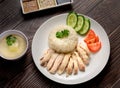 Hainanese chicken rice with soup and three sauces on dark wood table texture Royalty Free Stock Photo