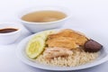 Hainanese chicken rice, steamed chicken, chicken blood and white rice on brown cloth background.