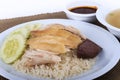 Hainanese chicken rice, steamed chicken, chicken blood and white rice on brown cloth background.