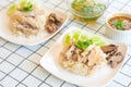 Hainanese Chicken Rice in white plate on the table with soup and spicy dipping sauce Royalty Free Stock Photo