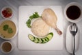 Hainanese chicken rice on a white table background, Steamed chicken rice with spicy sauces and chicken soup, Royalty Free Stock Photo