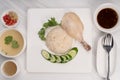 Hainanese chicken rice on a white table background, Steamed chicken rice with spicy sauces and chicken soup, Royalty Free Stock Photo