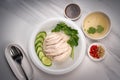 Hainanese chicken rice on a white table background, Steamed chicken rice with spicy sauces and chicken soup, Royalty Free Stock Photo