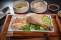 Hainanese chicken rice on a white table background, Steamed chicken rice with spicy sauces and chicken soup, Royalty Free Stock Photo