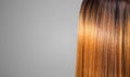 Hair. Beautiful healthy long smooth flowing brown hair close-up texture. Dyed straight shiny red hair background, coloring, extens