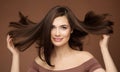 Hair Beauty Model. Brunette Woman with Straight Hairstyle flying on Wind over Dark Beige. Young Smiling Girl with Smooth Skin Make Royalty Free Stock Photo