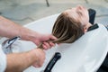 Hair care in modern spa salon. Male hairdresser washing teen girl's hairs Royalty Free Stock Photo