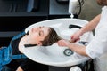 Hair care in modern spa salon. Male hairdresser washing teen girl's hairs Royalty Free Stock Photo