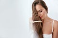 Hair Care. Woman Combing Beautiful Long Hair With Wooden Brush